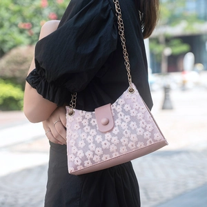 Sac bandoulière rose brodé de marguerites avec chaîne dorée pour un style estival