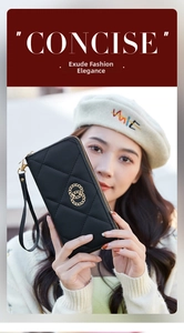 Detail of black quilted long wallet featuring double gold rings and convenient wrist strap