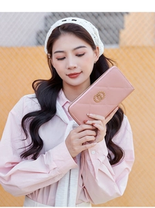 Detail of pink quilted long wallet with golden double ring buckle and wrist strap