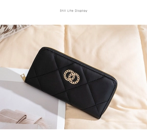 Macro detail of black quilted long wallet with elegant golden chain ring decoration