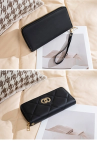 Detail of black quilted leather long wallet with double zipper and gold ring hardware