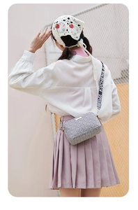 Detail of crossbody camera bag with geometric pattern and wide jacquard strap
