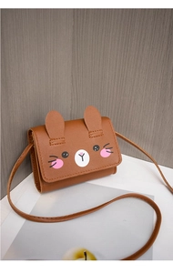 Detail of a brown cartoon animal mini crossbody bag with cute ears and round eyes