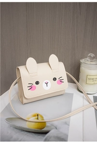 Close-up of beige PU leather mini crossbody bag with cute 3D bunny ears and face print