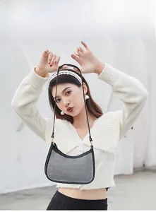 Hobo bag featuring black and white grid texture and gold ring hardware on a model