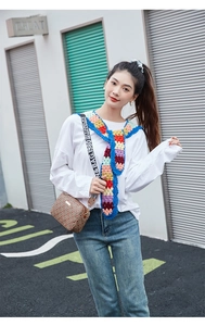 Detail of a vintage geometric shoulder bag paired with a colorful handmade crochet scarf