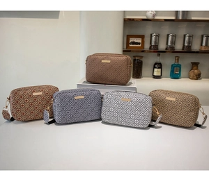 Detail shot of stylish camera bags with geometric floral prints and golden metal hardware