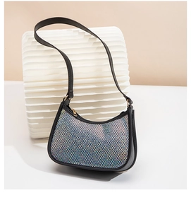 Close-up of black shell-shaped makeup bag with shimmering rhinestones and PU strap