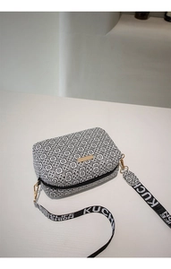 Close-up of black and white geometric crossbody bag with a jacquard lettering strap