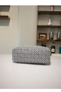 Detailed view of vintage black and white floral pattern on a compact crossbody bag