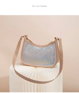 Close-up of shell-shaped handbag with colorful rhinestones and champagne leather strap
