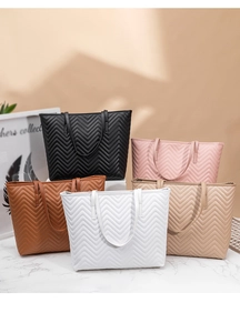 Gros plan de grands sacs cabas matelassés en cinq couleurs avec texture en V raffinée