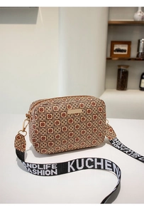 Detail of checkered crossbody camera bag featuring a stylish logo ribbon strap