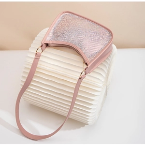 Detail view of pink seashell-shaped bag with sparkling rhinestones and gold hardware