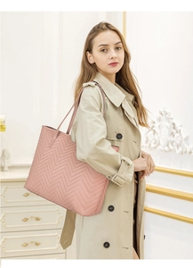 Grand sac cabas matelassé rose avec coutures en V porté par un mannequin en trench