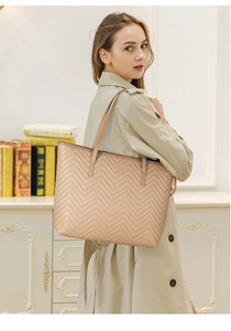 Sac fourre-tout beige élégant avec matelassage en V porté par un mannequin dans un cadre cosy