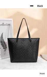 Vue détaillée du sac cabas noir matelassé en V avec finition élégante sur surface en marbre