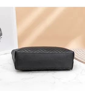 Vue détaillée du fond du sac cabas matelassé noir sur une surface en marbre