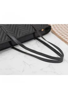 Détails des poignées matelassées et des coutures en V de ce grand sac cabas noir