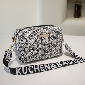 Minimalist crossbody camera bag with geometric floral pattern and wide woven strap