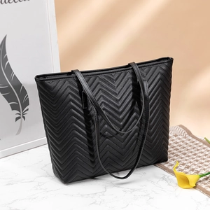 Grand sac cabas noir en cuir matelassé avec motif en V sur surface en marbre