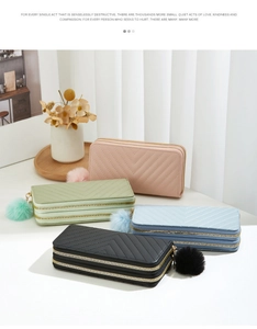 Detailed view of four long double-zip wallets in pastel colors with V-quilt texture and pompoms