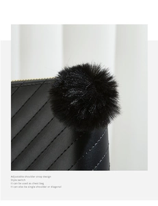 Detail of black quilted texture on women's long wallet with soft pompom and gold zipper