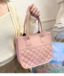 Detail of pink quilted tote bag with smooth faux leather texture and dual handles