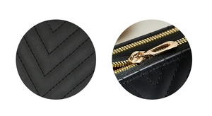 Detail of black quilted leather with V-pattern stitching and premium gold metal zipper