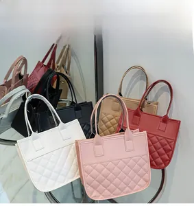 Group display of quilted faux leather tote bags in white, pink, red, black, and beige colors