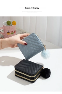 Detail of double-layer quilted mini wallets with pom-pom charms in blue and black