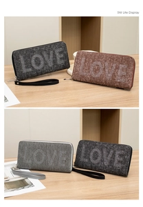 Close-up of denim texture wallet with LOVE rhinestone embellishment and wrist strap