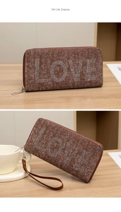 Macro view of brown canvas wallet with sparkling rhinestone LOVE lettering and wrist strap