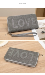 Detail of grey denim wallet with LOVE rhinestone lettering and a detachable wrist strap
