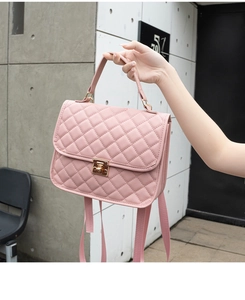 Detail shot of pink quilted backpack showing gold turn-lock closure and leather texture