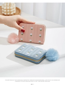 Detailed view of mini PU leather purses with floral embroidery and soft pompom charms
