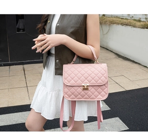 Close-up of pink quilted texture with gold square turn-lock on luxury crossbody bag