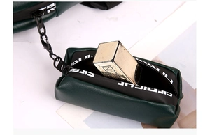 Dettaglio della borsa portamonete in pelle verde con spazio per rossetto e cerniera