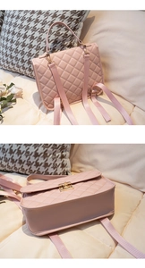 Detail showing pink quilted texture, fabric strap, and gold metal lock on the backpack