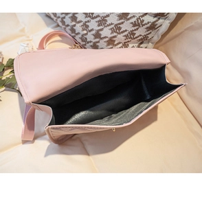 Top view of pink quilted handbag showing spacious black interior and metal lock closure