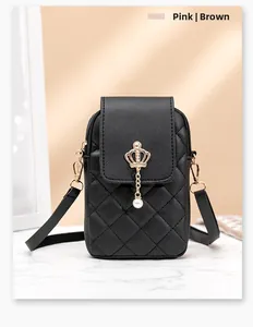 Detailed view of black quilted phone bag featuring a gold crown and pearl pendant