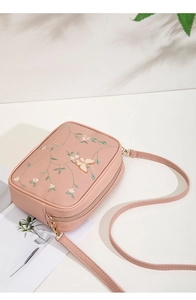 Detail of pink floral camera bag with delicate gold butterfly embroidery and zipper top