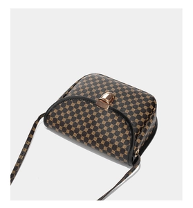 Détail du motif floral vintage sur sac en cuir avec fermoir sphérique doré élégant