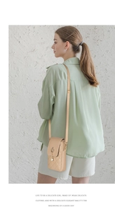 Detail of beige quilted mini crossbody bag with crown pendant and pearl accessory