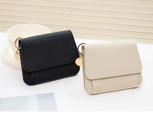 Detailed view of mini lychee leather coin purses with elegant gold metal pendants