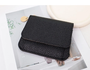 Detail of black lychee grain leather wallet with a round gold metal zipper puller
