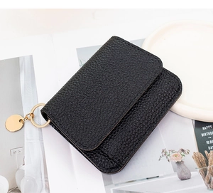Detail of black lychee grain leather wallet with polished gold hardware and ring clasp