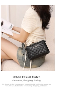 Detail view of a black quilted crossbody bag with a gold chain strap on a model
