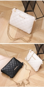 Detail of quilted leather crossbody bag with gold chain strap and metal logo