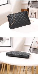 Detail view of black quilted PU leather crossbody bag with elegant gold chain strap